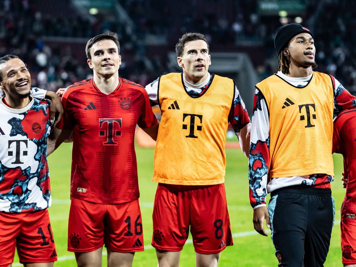 Leroy Sané, Joao Palhinha und Leon Goretzka haben sich eingehakt und feiern vor den Fans.