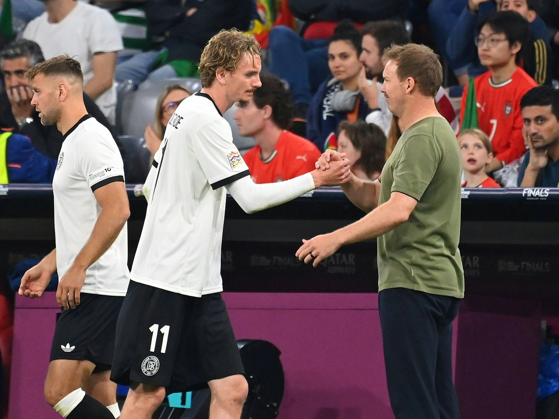 Nick Woltemade klatscht Bundestrainer Julian Nagelsmann nach seiner Auswechslung ab. Dahinter steht Niclas Füllkrug zur Einwechslung bereit.