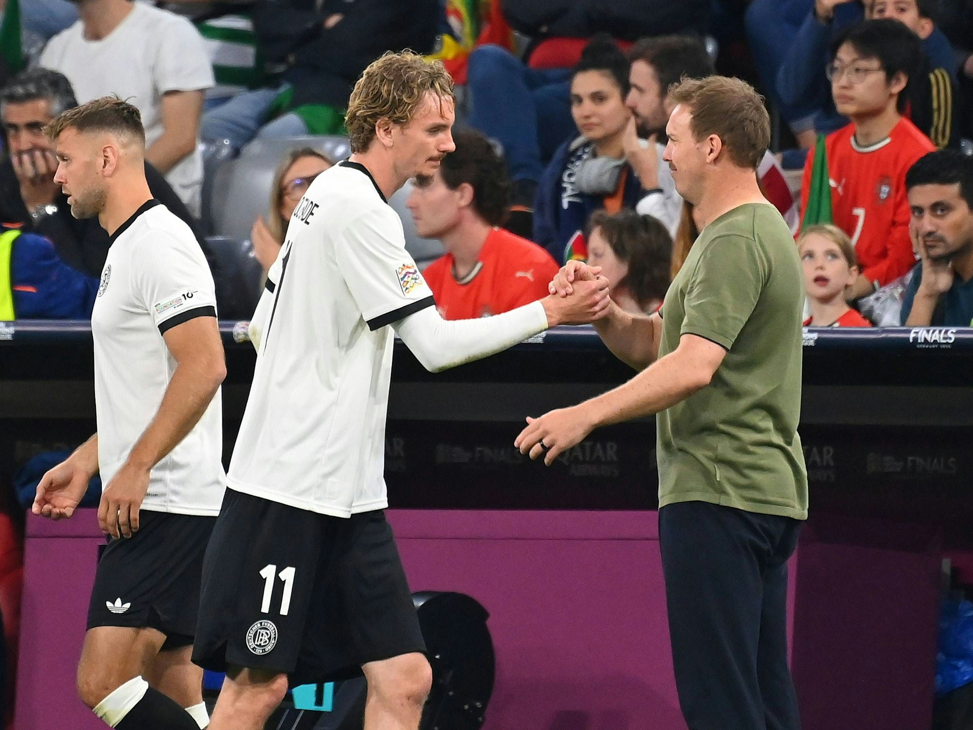 Nick Woltemade klatscht Bundestrainer Julian Nagelsmann nach seiner Auswechslung ab. Dahinter steht Niclas Füllkrug zur Einwechslung bereit.