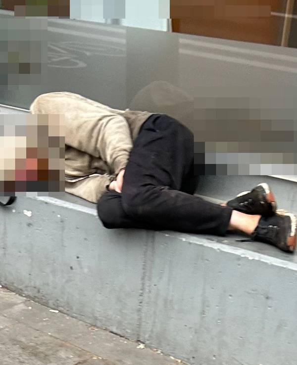 Ein Obdachloser schläft vor einem Geschäft in Köln.