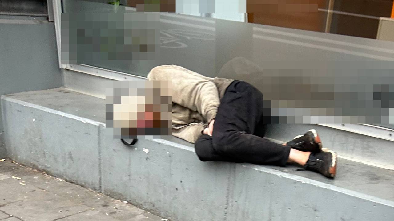 Ein Obdachloser schläft vor einem Geschäft in Köln.