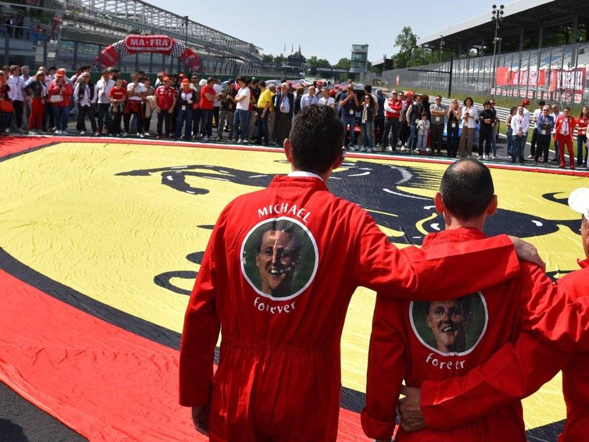 Ferrari-Besitzer erinnern in Monza mit einer Riesen-Fahne und Overalls mit der Aufschrift ‚Michael forever‘ an Rekordweltmeister Michael Schumacher.