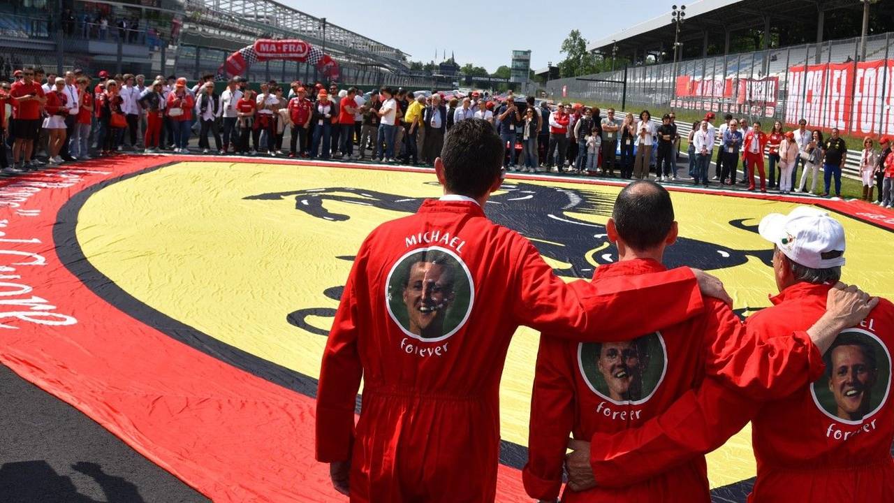 Ferrari-Besitzer erinnern in Monza mit einer Riesen-Fahne und Overalls mit der Aufschrift ‚Michael forever‘ an Rekordweltmeister Michael Schumacher.