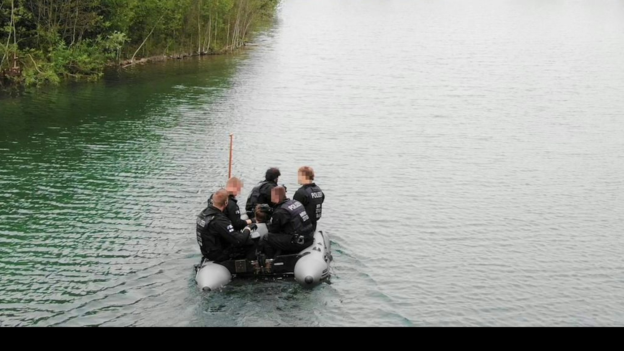Polizeibeamte auf einem Boot bei einer Festnahme auf einer Insel im Königshüttesee.