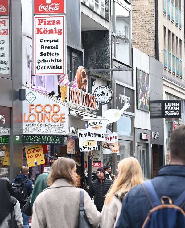 Menschen laufen durch eine Einkaufsstraße.