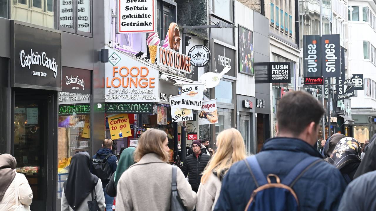 Menschen laufen durch eine Einkaufsstraße.