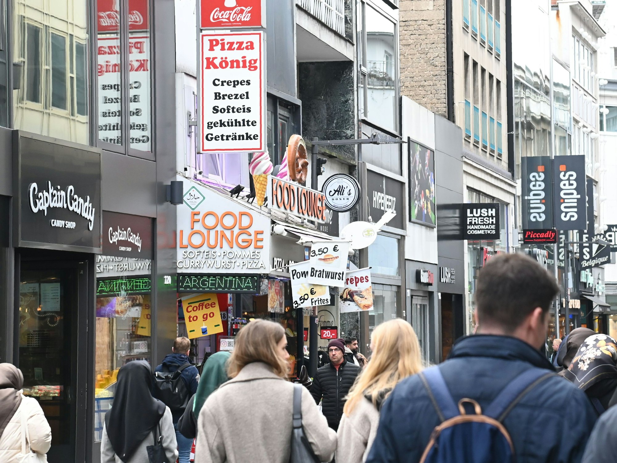 Menschen laufen durch eine Einkaufsstraße.