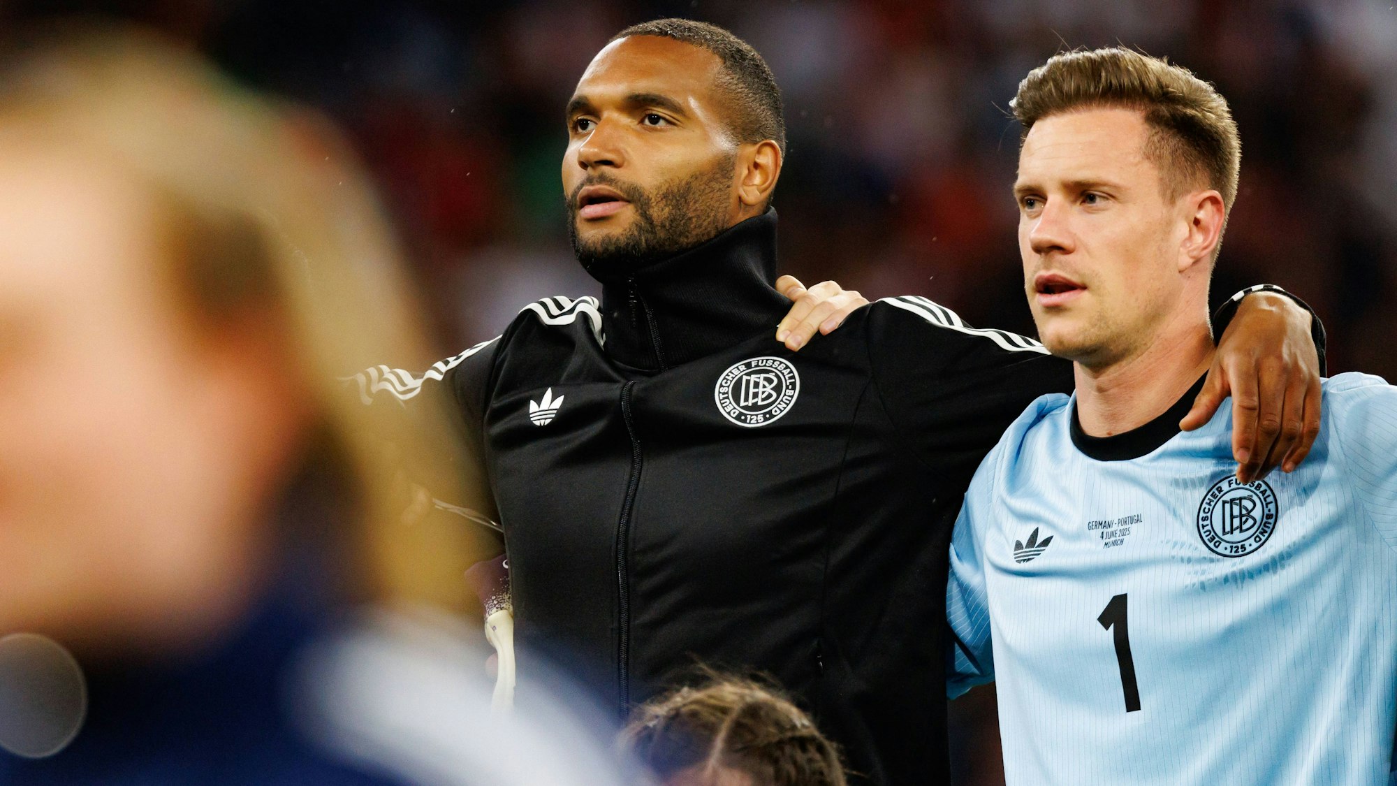 Jonathan Tah and Marc Andre Ter Stegen stehen bei der Nationalhymne Arm in Arm.