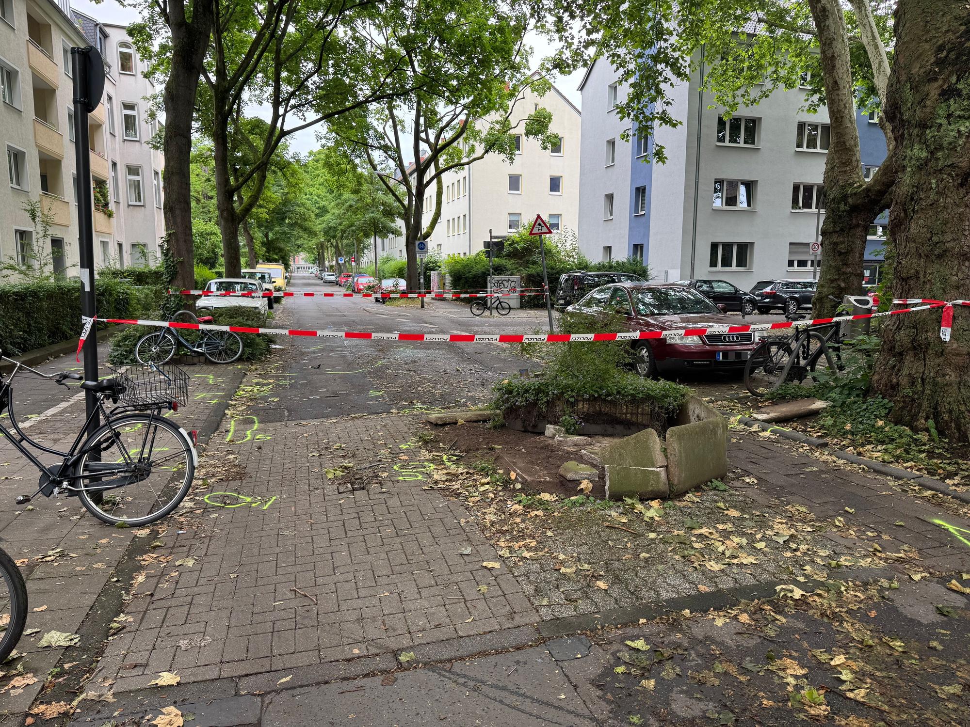 Die Polizei hat den Bereich um einen zerstörten Blumenkübel, der eine Straße verengt, mit Flatterband abgesperrt.