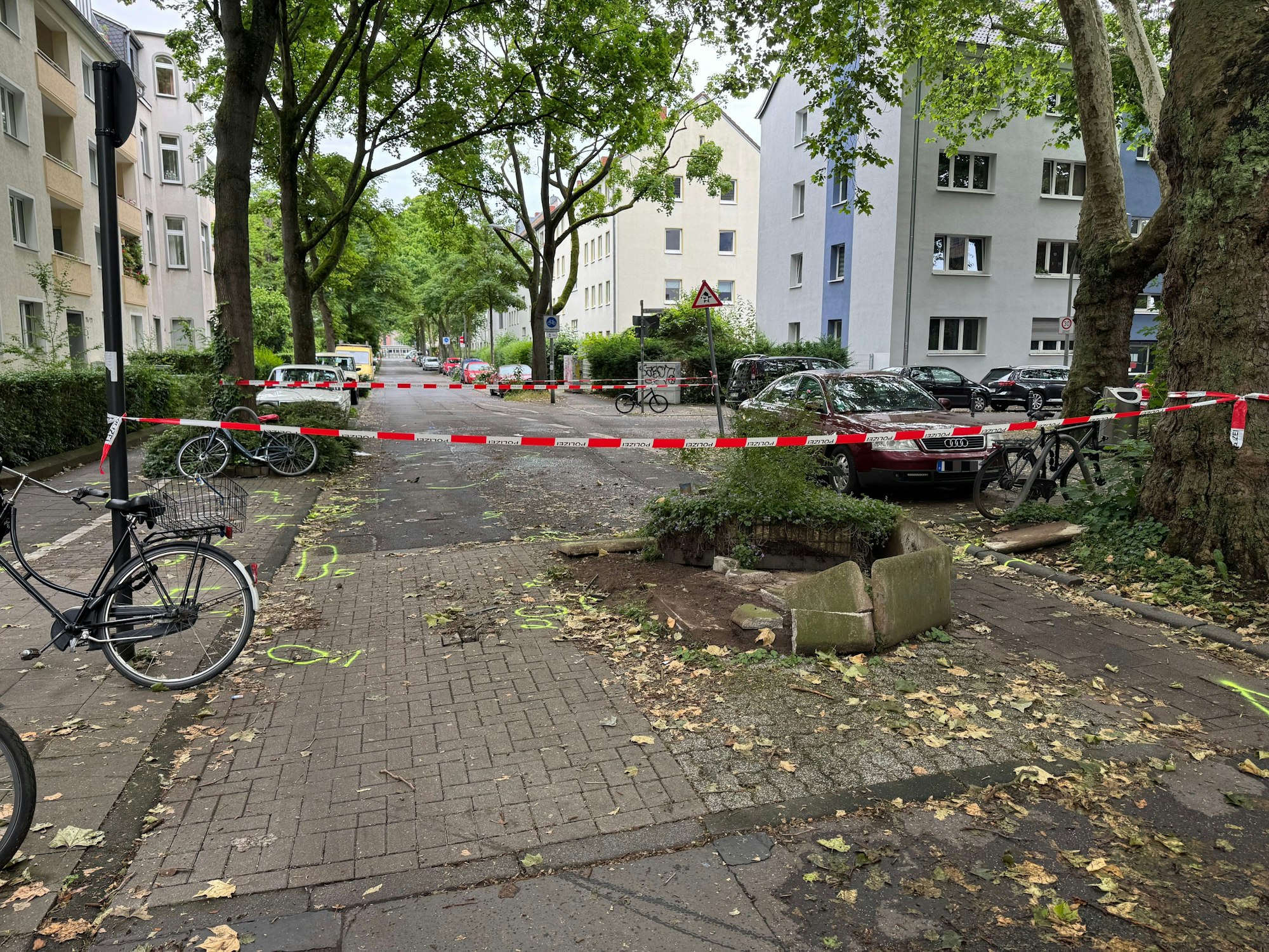 Die Polizei hat den Bereich um einen zerstörten Blumenkübel, der eine Straße verengt, mit Flatterband abgesperrt.
