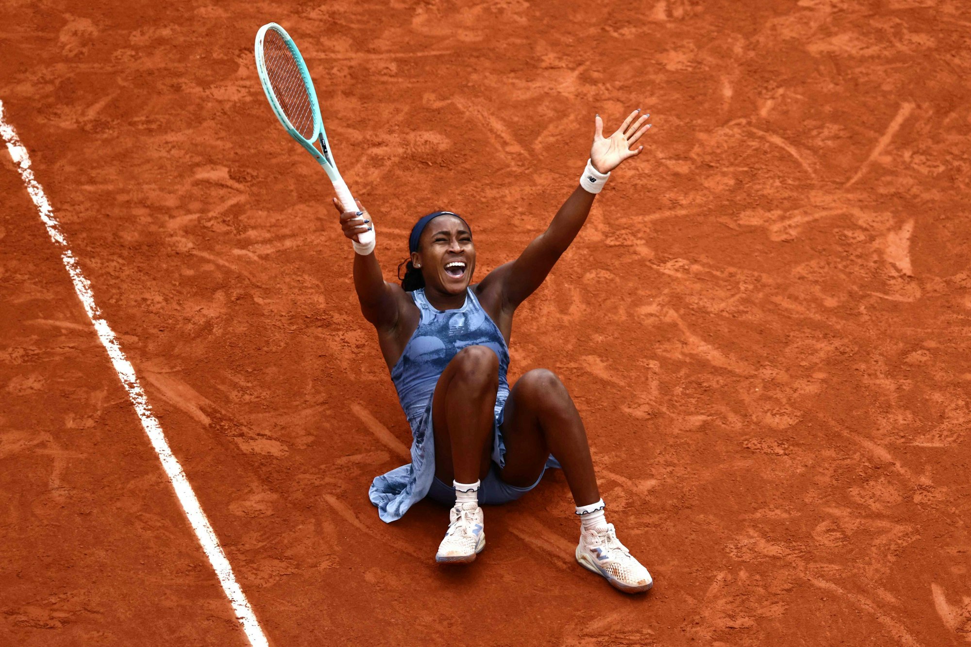 Coco Gauff liegt jubelnd im roten Sand.