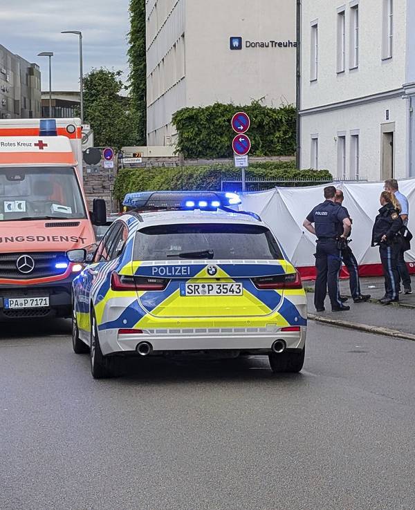 Polizei und Rettungskräfte sind neben einem Sichtschutz im Einsatz. In Passau ist ein Mann mit einem Wagen in eine Menschengruppe gefahren.