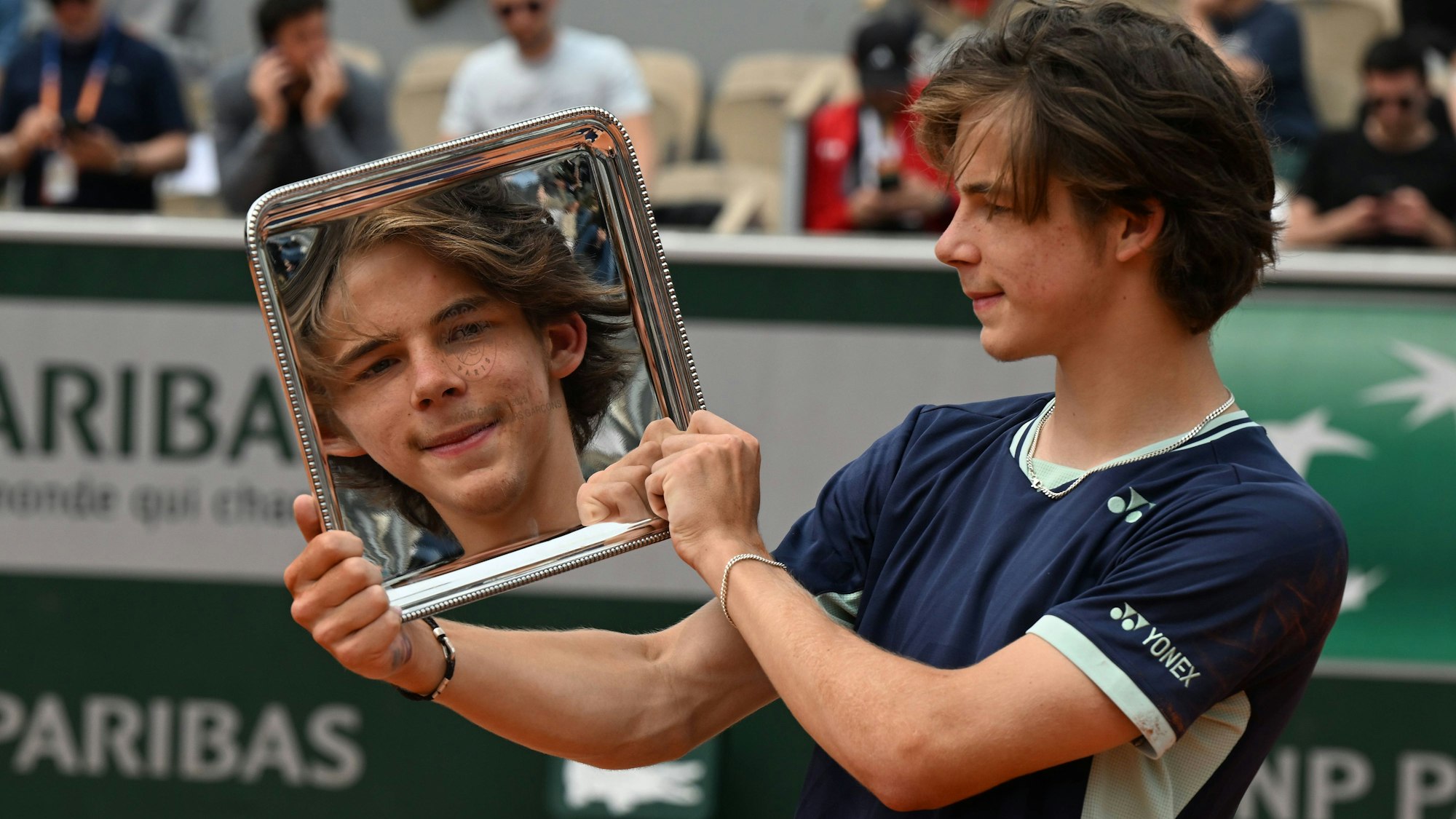 Das Gesicht von Niels McDonald spiegelt sich in seiner Siegertrophäe.