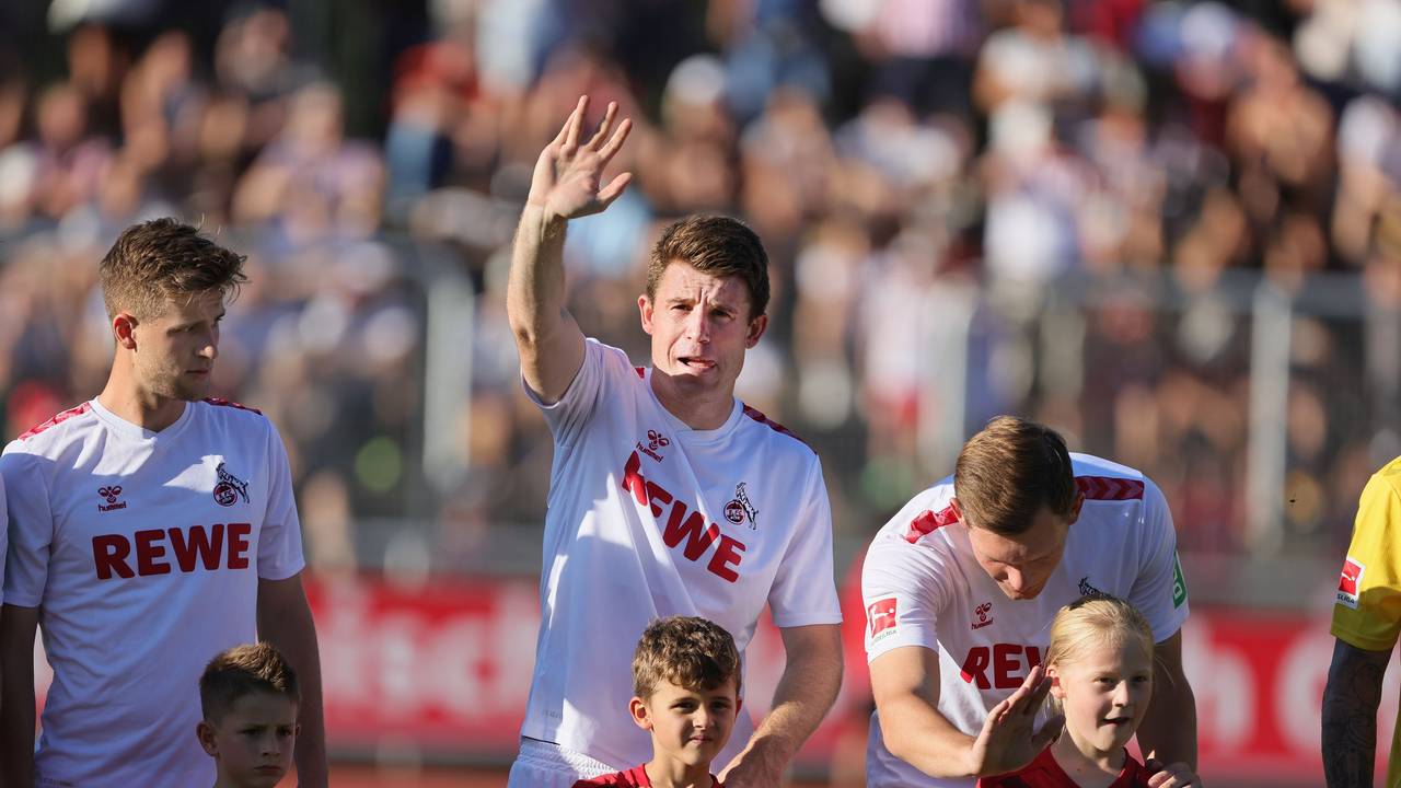 Dominique Heintz winkt auf die Tribüne, Luca Kilian spricht mit seinem Einlaufkind.