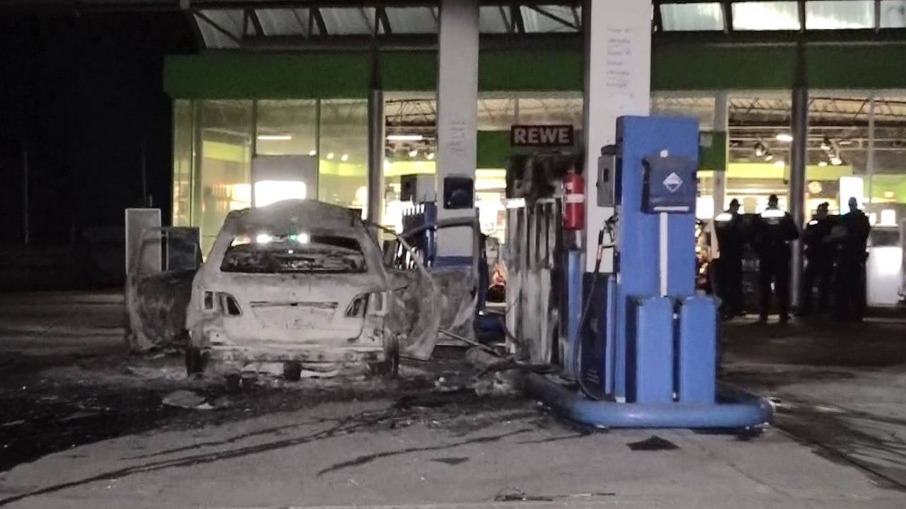 Ein ausgebranntes Fahrzeug steht an einer Zapfsäule auf einer Tankstelle in Hannover.