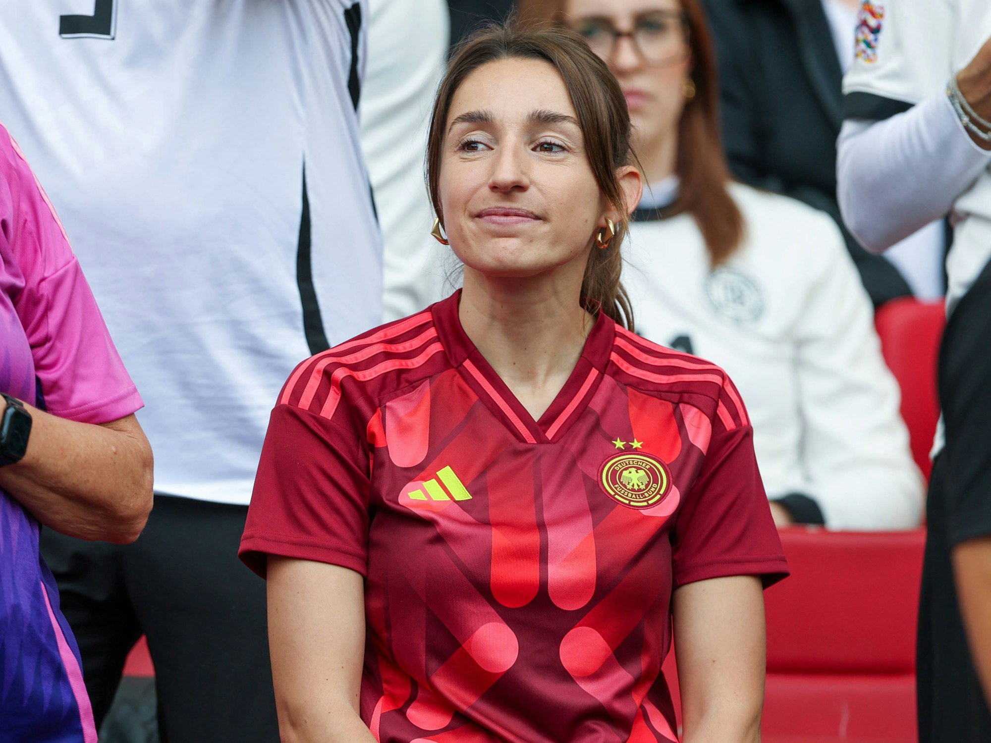 Julian Nagelsmanns Freundin Lena Wurzenberger sitzt im roten DFB-Trikot auf der Tribüne.