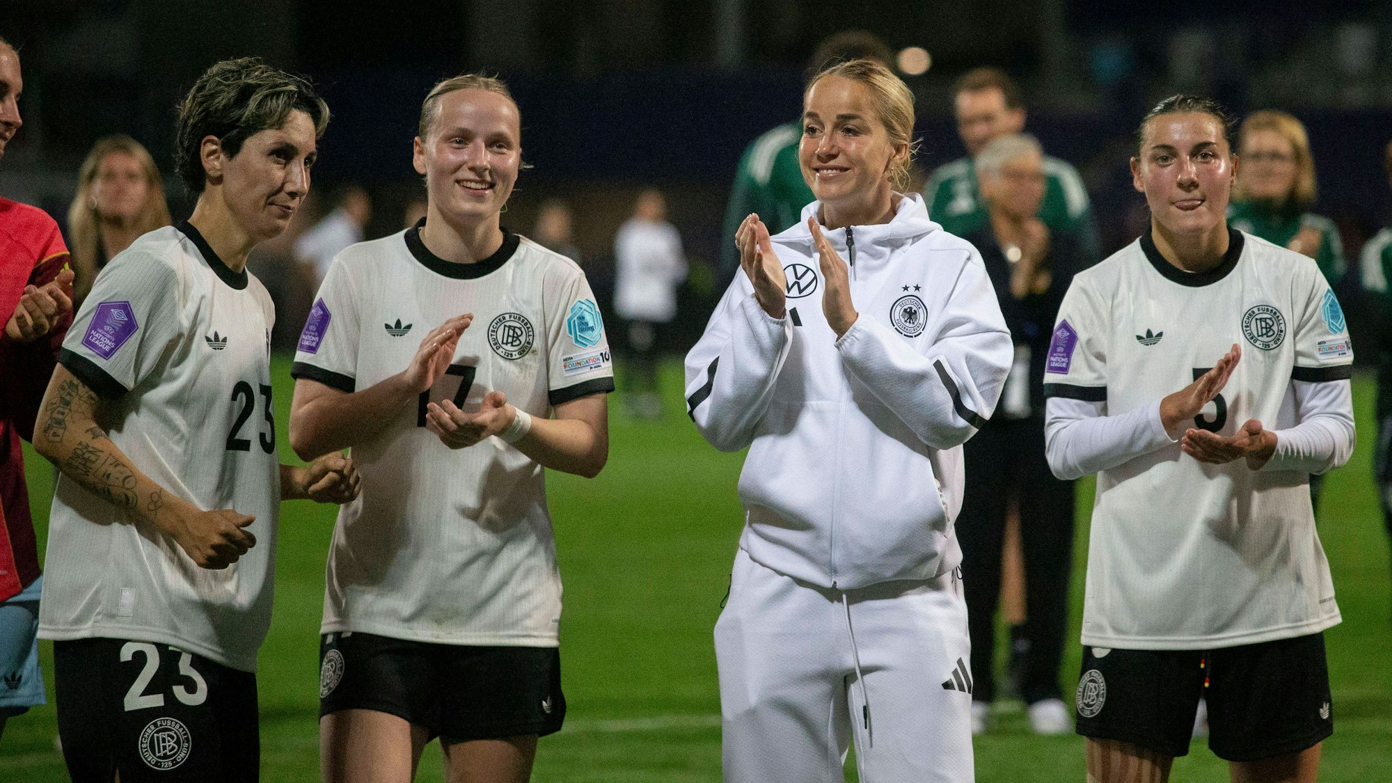 Sara Doorsoun, Franziska Kett, Giulia Gwinn und Carlotta Wamser stehen im DFB-Trikot gemeinsam auf dem Platz.