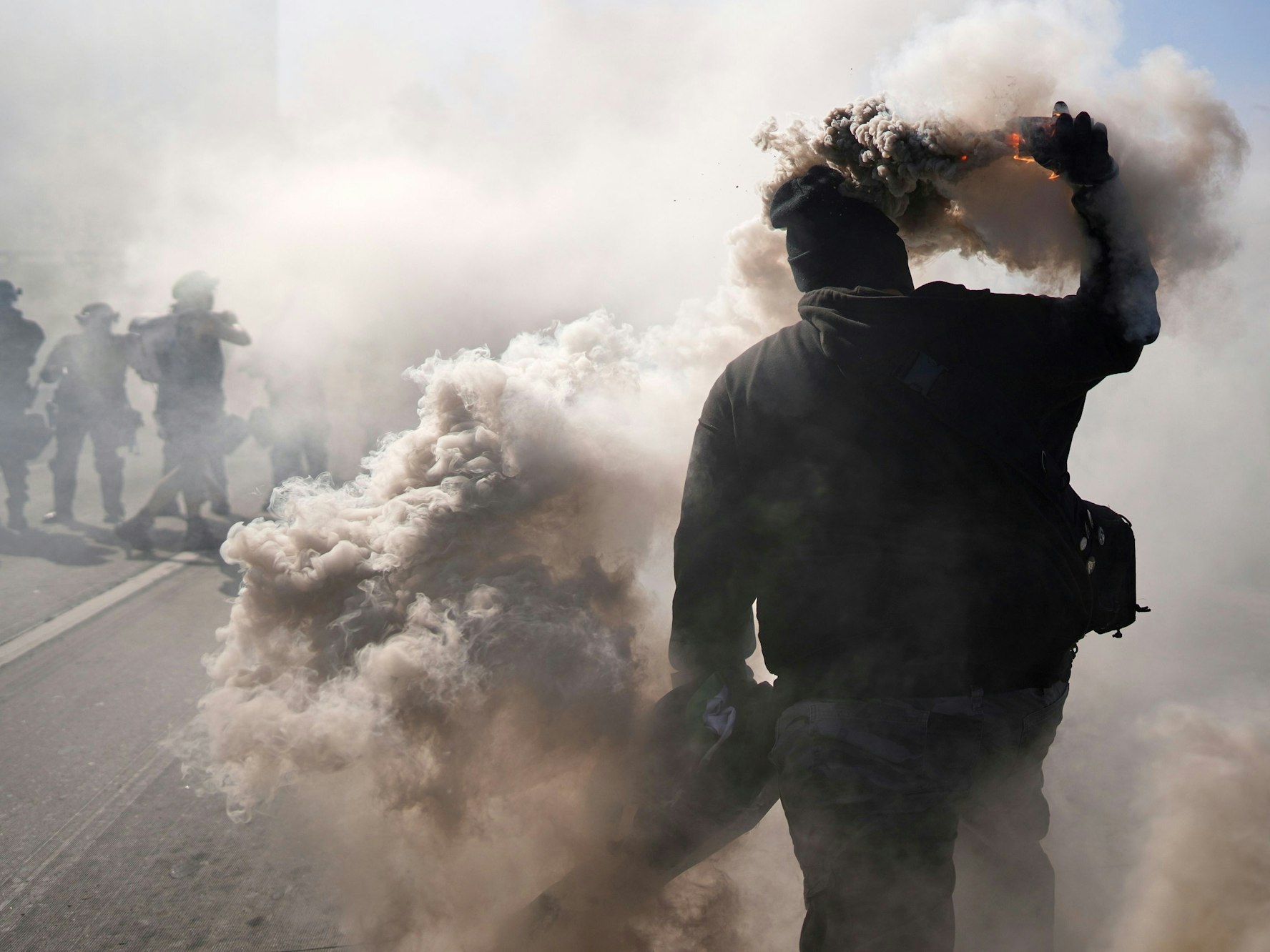 Ein Demonstrant wirft einen Rauchkanister auf den 101 Freeway in der Nähe des Metropolitan Detention Center in der Innenstadt von Los Angeles.