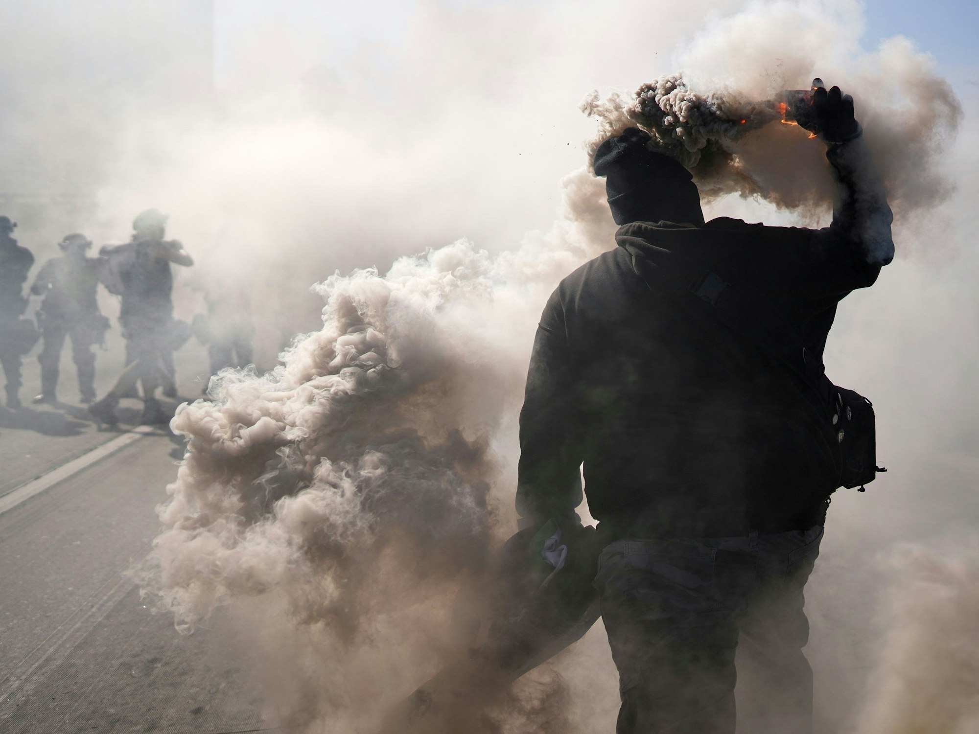 Ein Demonstrant wirft einen Rauchkanister auf den 101 Freeway in der Nähe des Metropolitan Detention Center in der Innenstadt von Los Angeles.