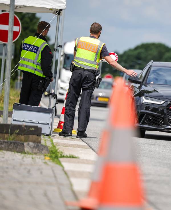 An der Grenze zu den Niederlanden auf der A3 in Emmerich kontrollieren zwei Bundespolizisten die nach Deutschland einfahrenden Fahrzeuge.
