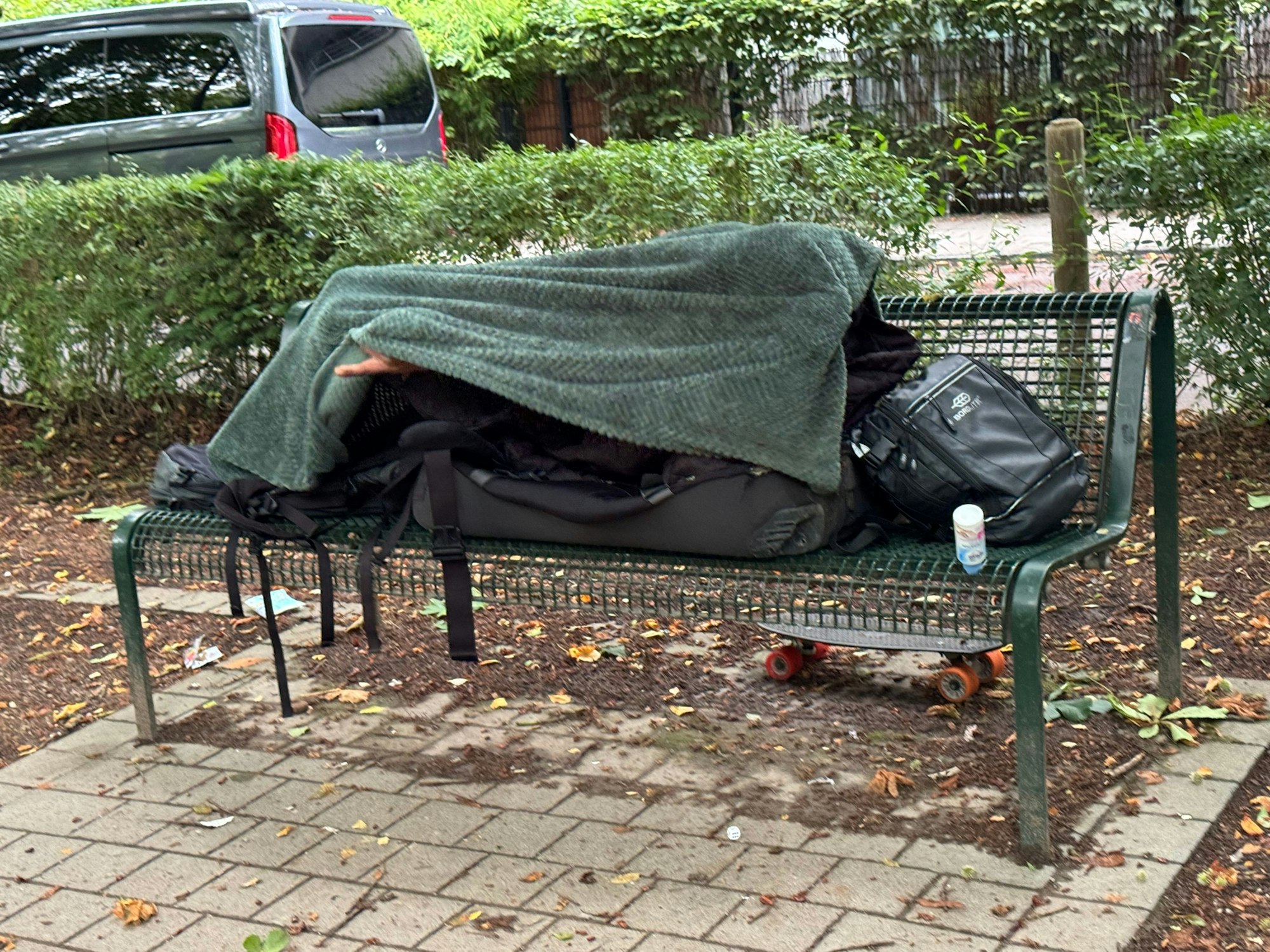 Am Rautenstrauch Kanal lebt ein Obdachloser auf einer Bank.