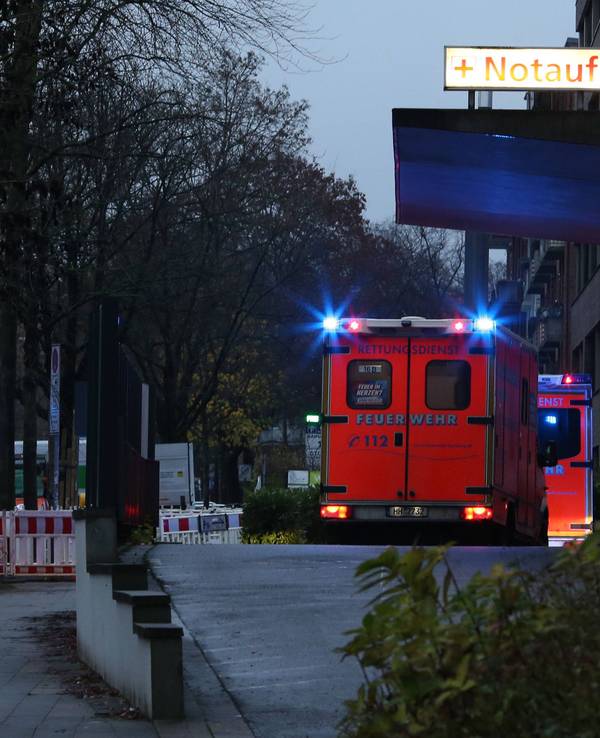 Rettungswagen mit Blaulicht stehen nachts vor einer Notaufnahme-