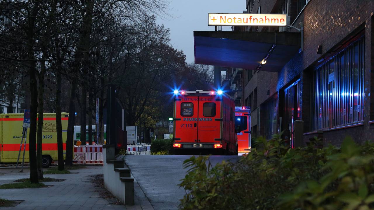 Rettungswagen mit Blaulicht stehen nachts vor einer Notaufnahme-