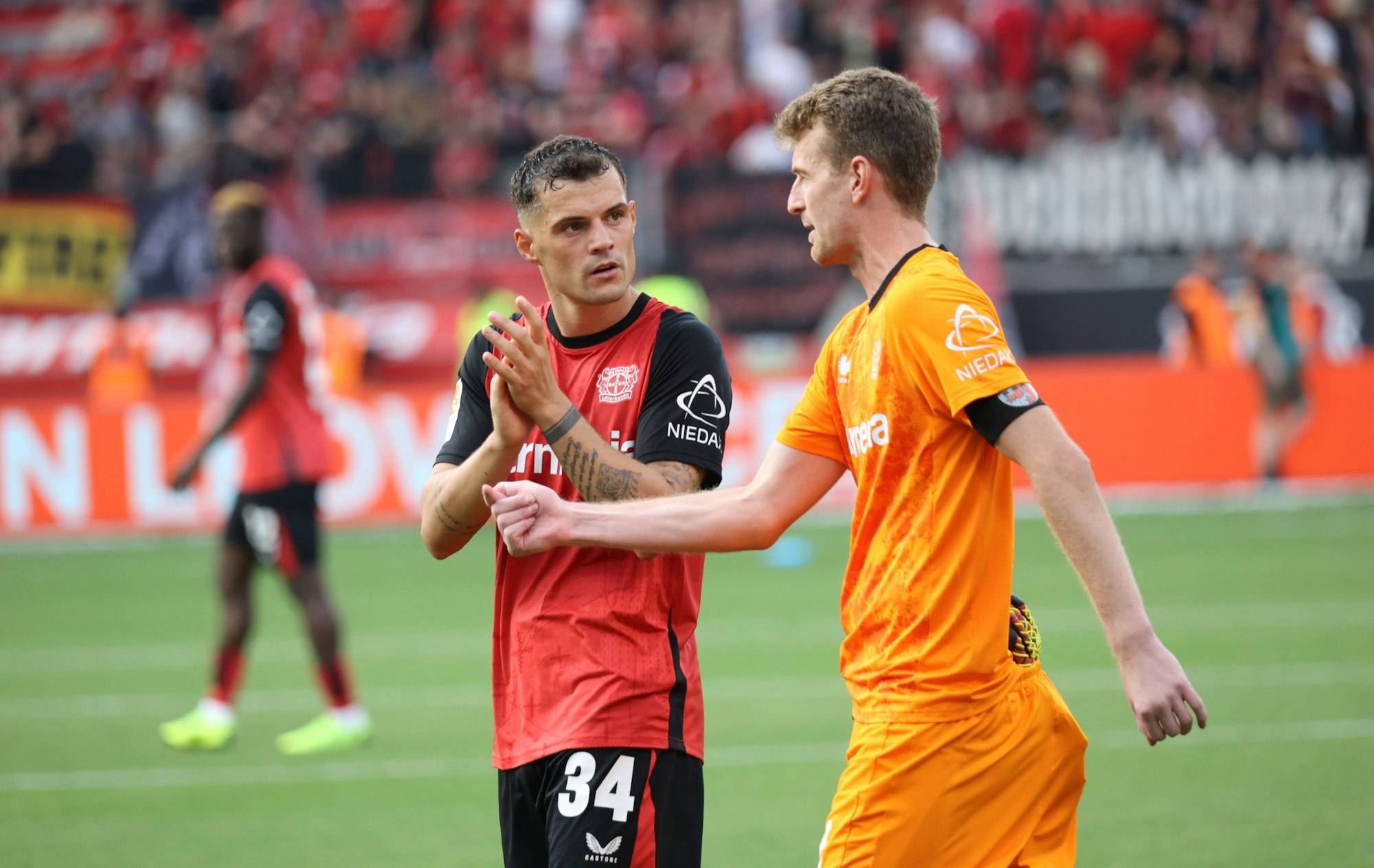 Lukas Hradecky und Granit Xhaka besprechen sich auf dem Platz.