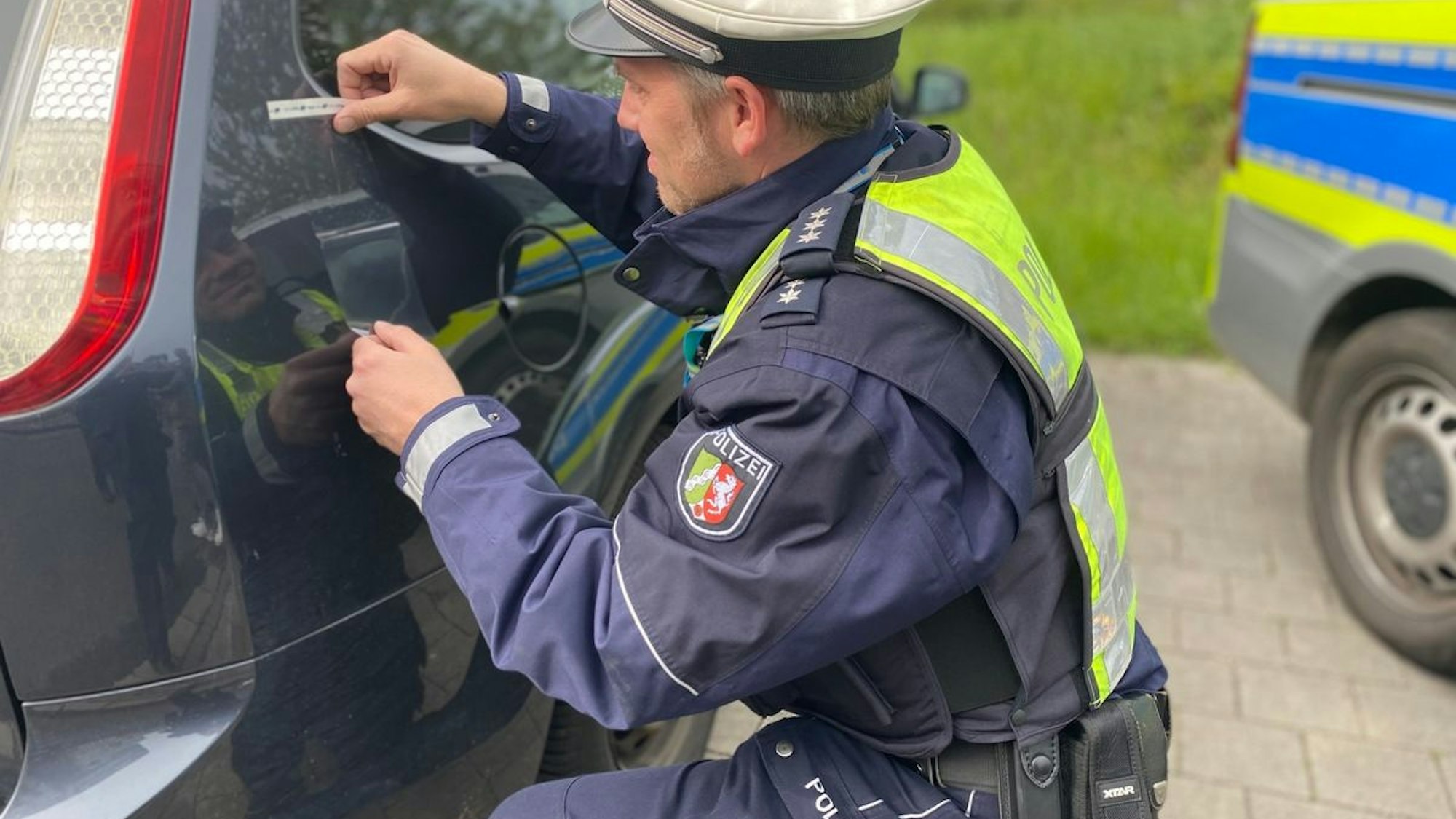 Polizeibeamter bei der Unfallaufnahme. Die Polizei im Kreis Mettmann sucht Zeugen zu mehreren Unfallfluchten in Erkrath, Hilden und Langenfeld.