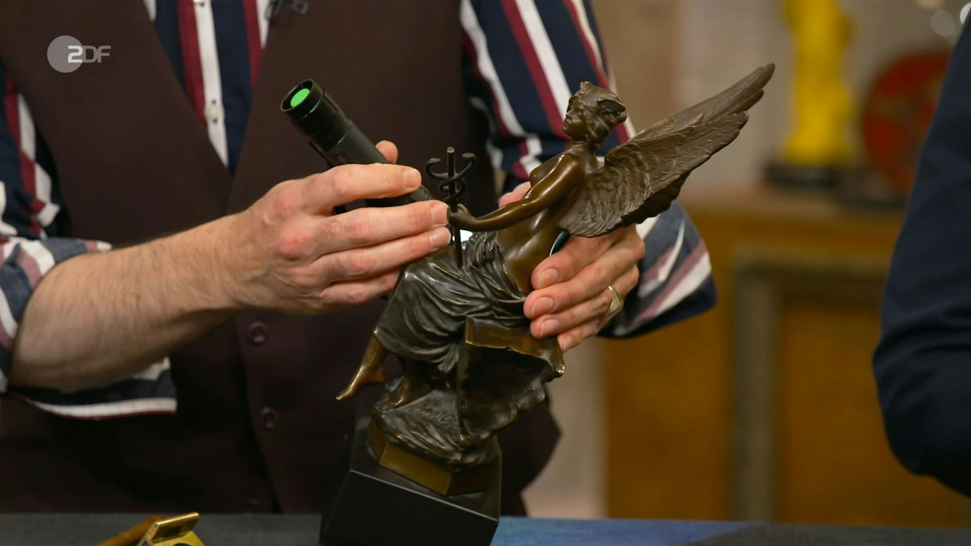 Eine beschädigte Bronze-Statuette von Oswald Schimmelpfennig wollte Wiebe für 1.000 Euro veräußern. Colmar Schulte-Goltz taxierte auf bis zu 1.200. Susanne Steiger war die geflügelte Figur 1.350 Euro wert. (Bild: ZDF)