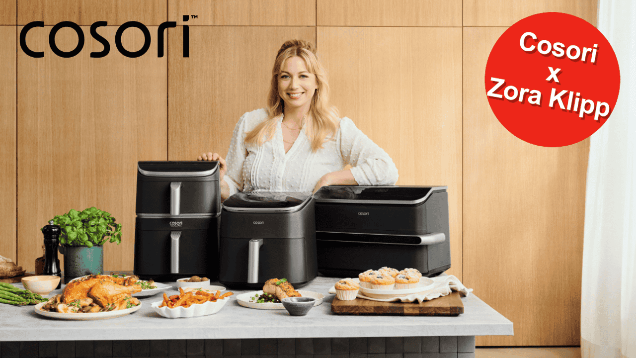 TV-Köchin Zora Klipp lächelnd hinter drei verschiedenen Cosori Heißluftfritteusen, umgeben von frisch zubereiteten Gerichten wie Hähnchen, Pommes und Muffins.