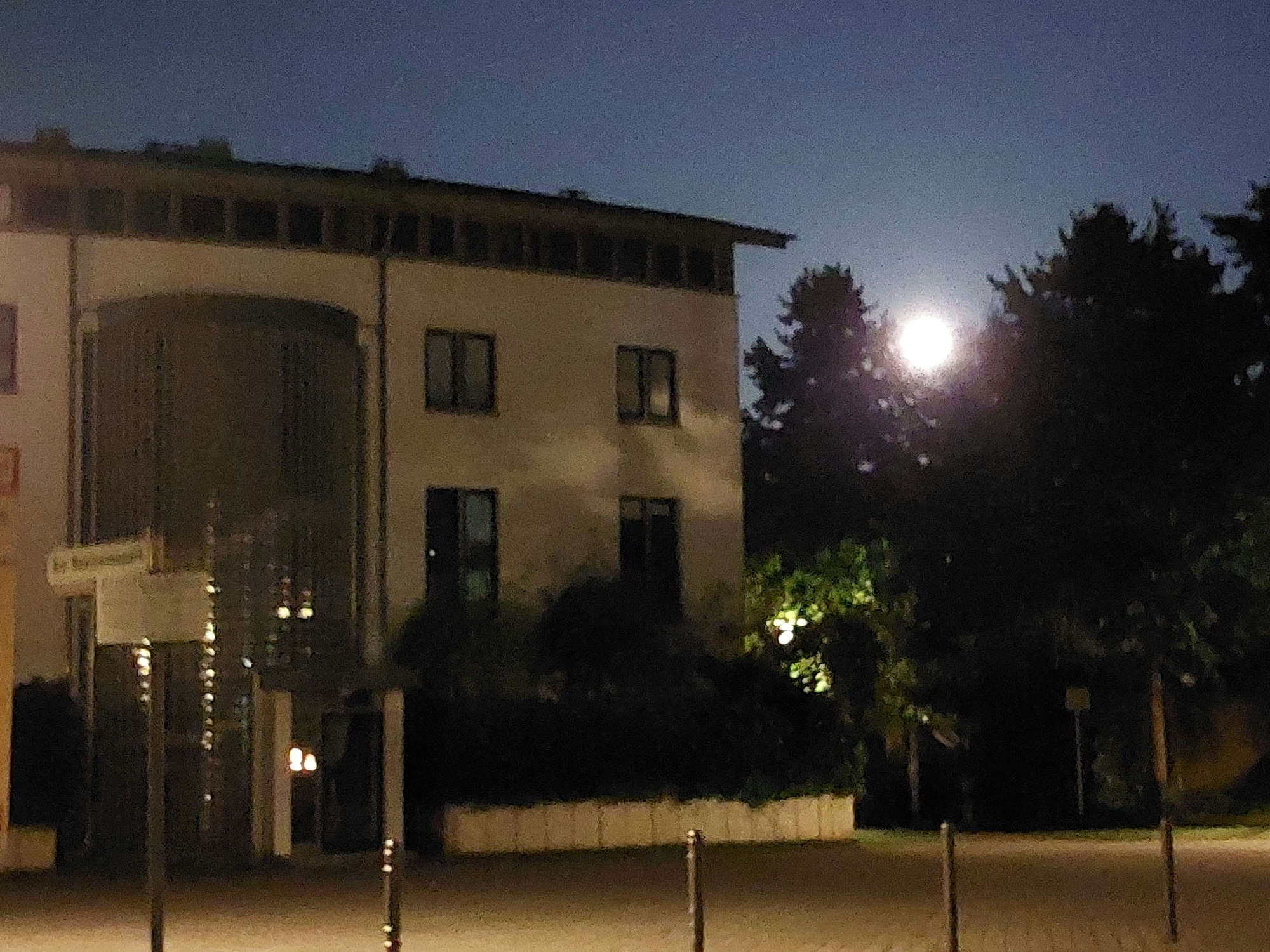 Vollmond neben einem Gebäude.