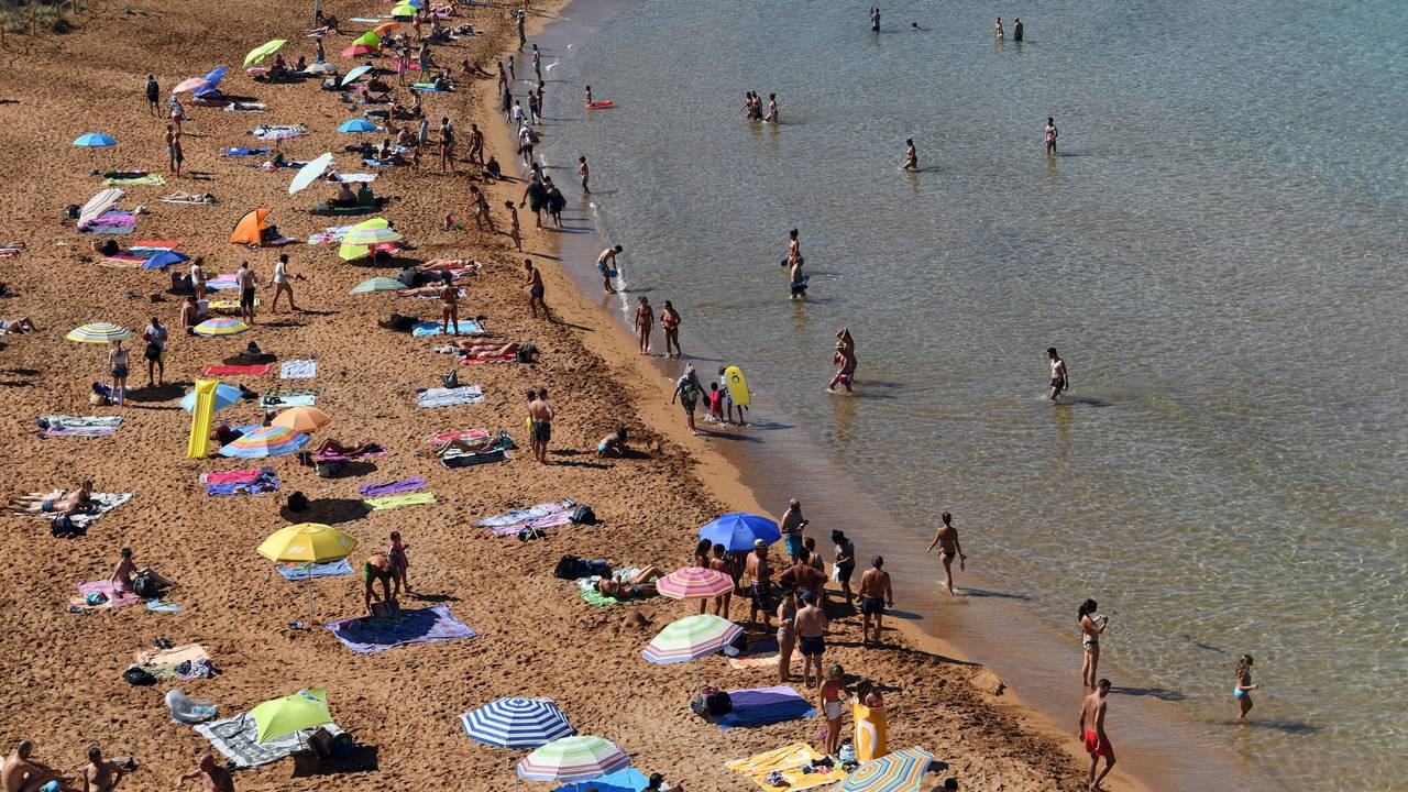 Urlauber und Urlauberinnen an einem Strand auf Menorca