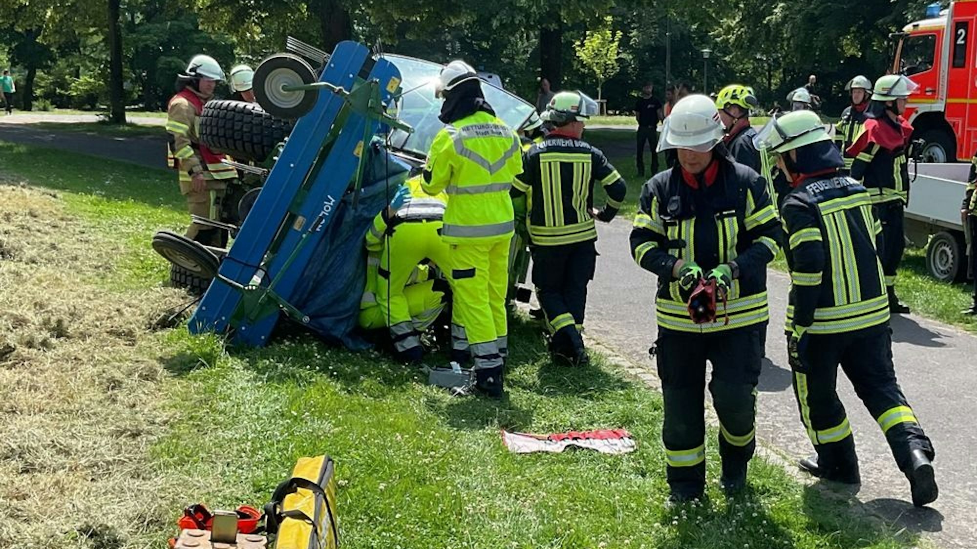 Einsatz der Feuerwehr Bonn nach einem Arbeitsunfall mit einem umgestürzten Traktor in der Beueler Rheinaue