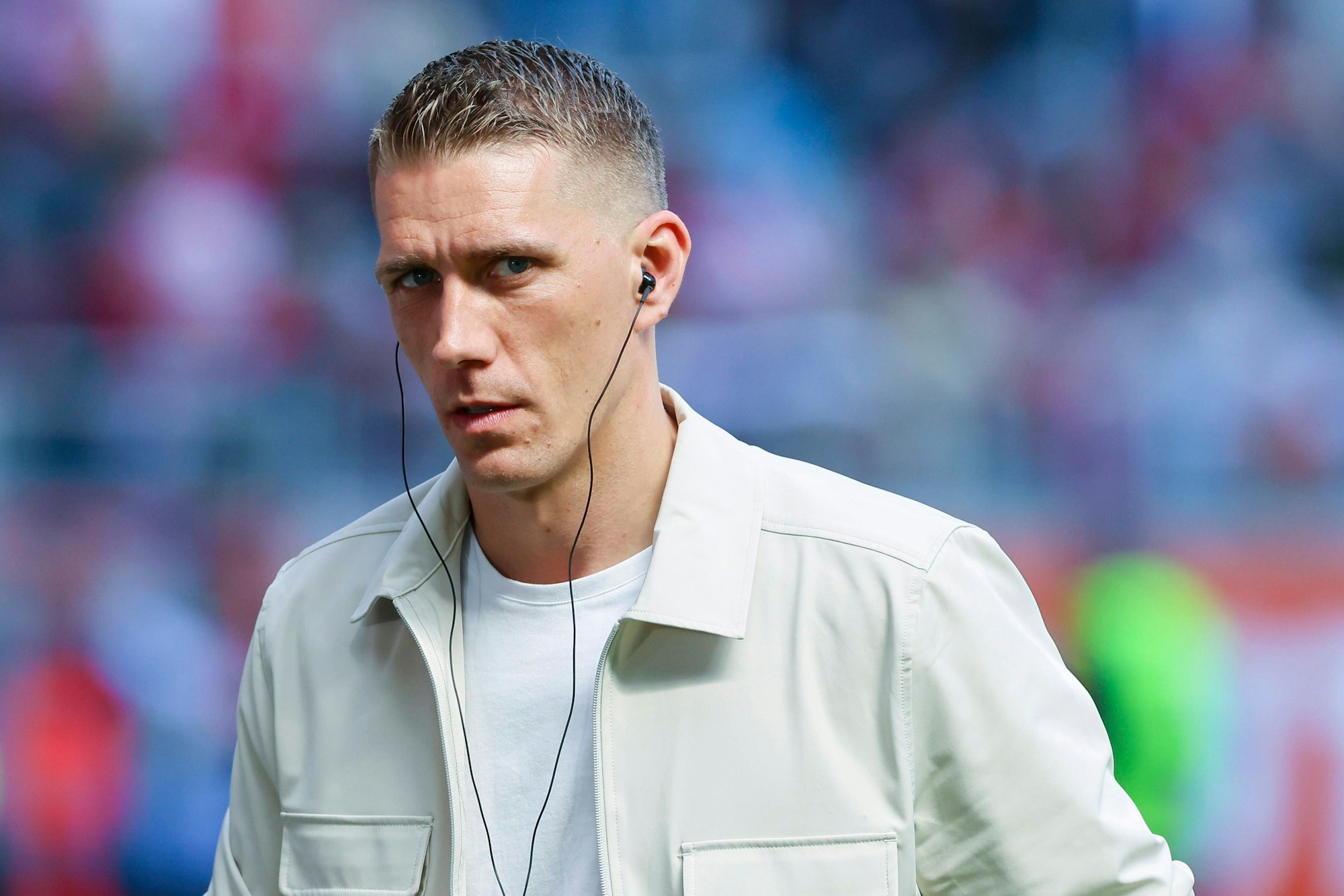 Nils Petersen mit Kopfhörern im Ohr als Experte am Rande eines Spiels.