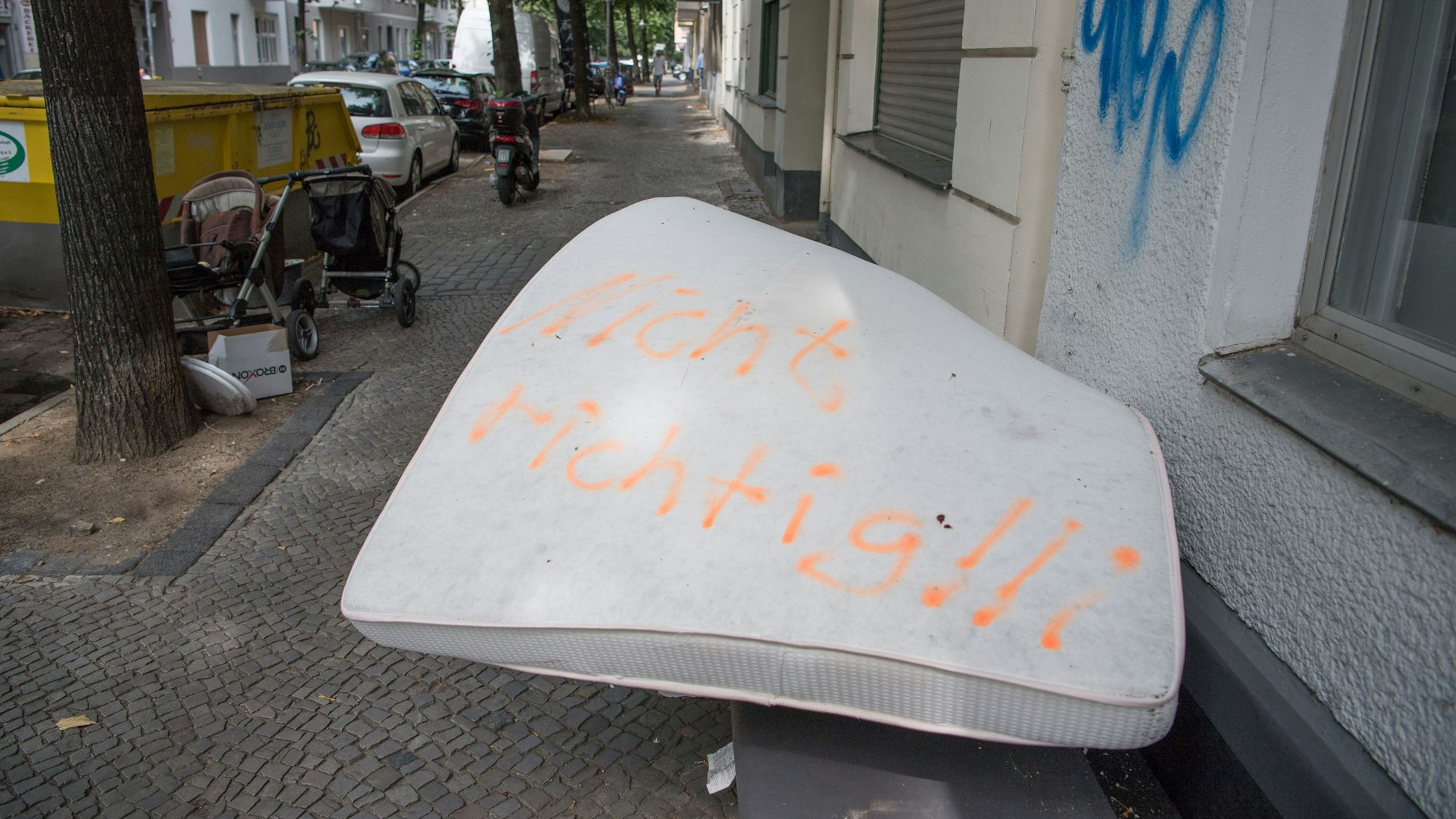 Eine illegal entsorgte Matratze liegt auf einem Gehweg, darauf wurden die Worte „Nicht richtig!!“ gesprüht.