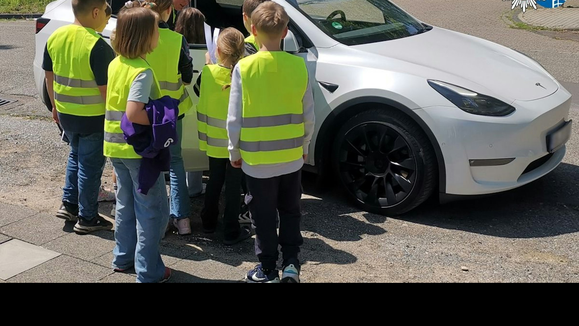 Grundschüler in Warnwesten sprechen mit Autofahrern während einer Verkehrsaktion der Polizei Oberhausen