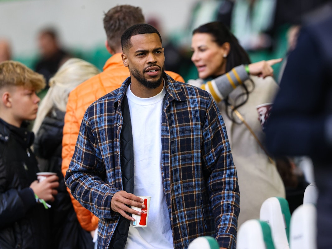 Lukas Nmecha mit einem Cola-Becher auf der Tribüne.