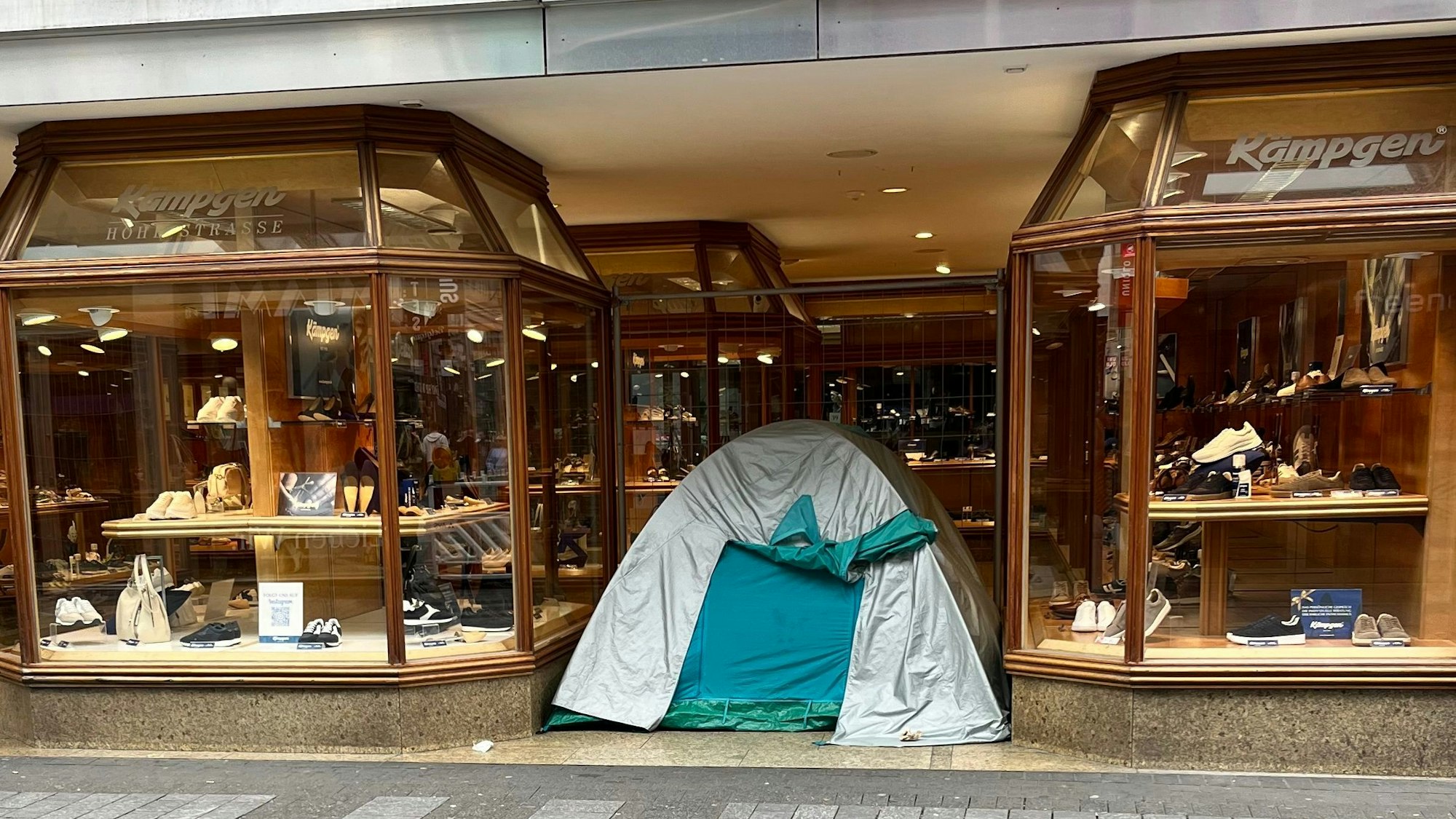 Ein Zelt steht im Eingangsbereich eines Schuhladens in der Kölner Innenstadt.