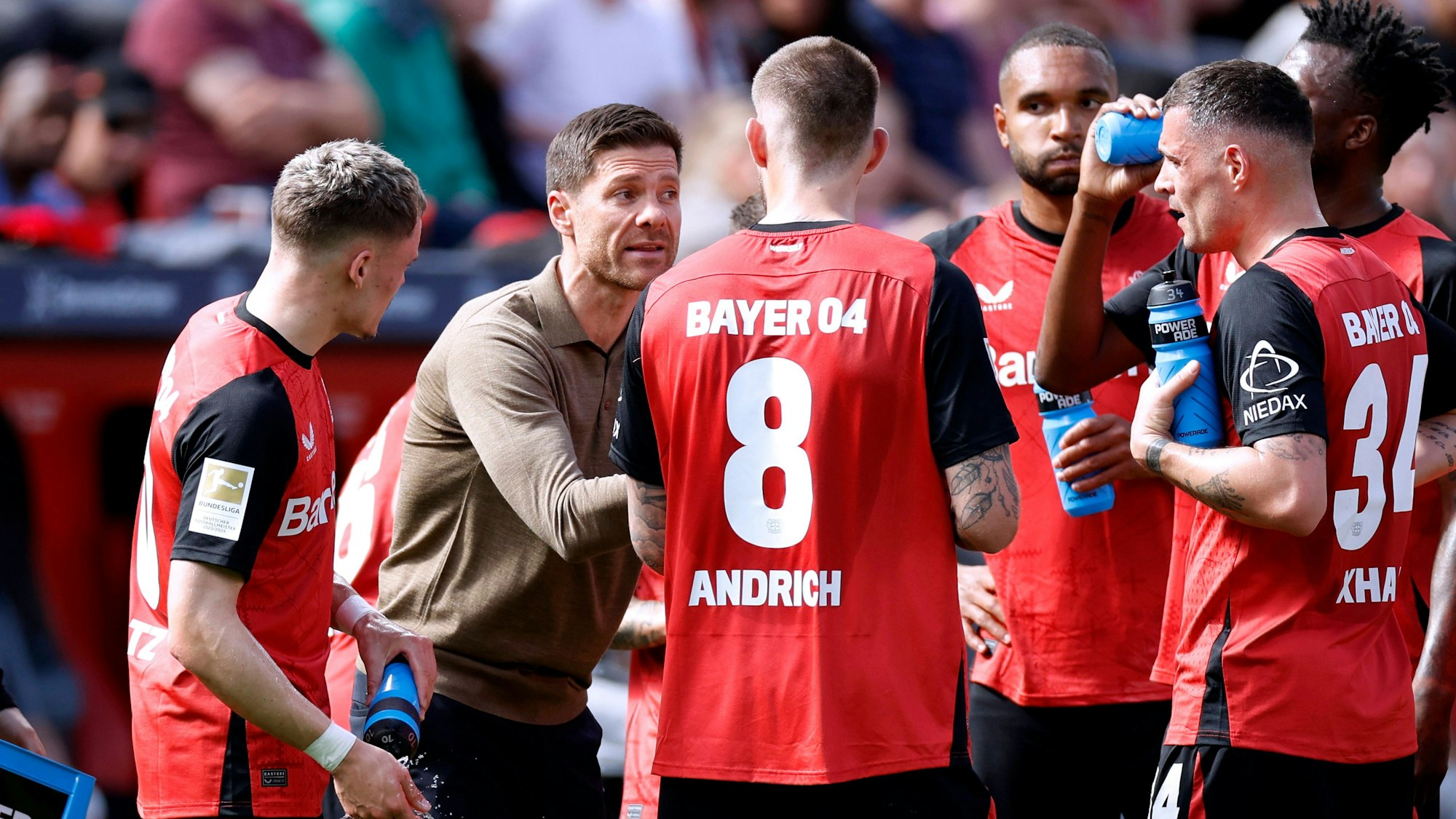 Xabi Alonso spricht am Rande eines Heimspiels mit seinen Leverkusen-Stars Florian Wirtz, Robert Andrich, Jonathan Tah, Edmond Tapsoba und Granit Xhaka.