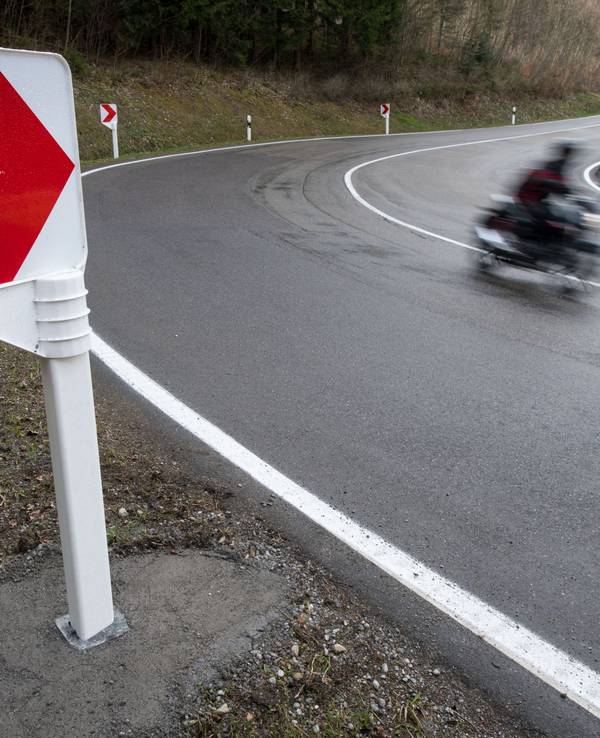 Ein Motorrad fährt auf einer Landstraße in einer Kurve.