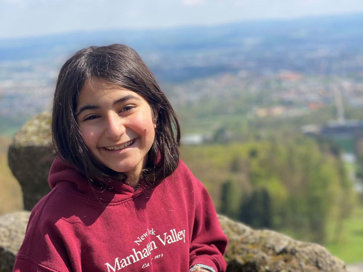 Ein Mädchen steht an einer Felsbrüstung.