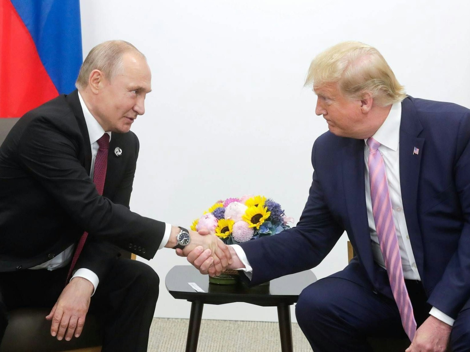 Wladimir Putin und Donald Trump schütteln sich die Hand.