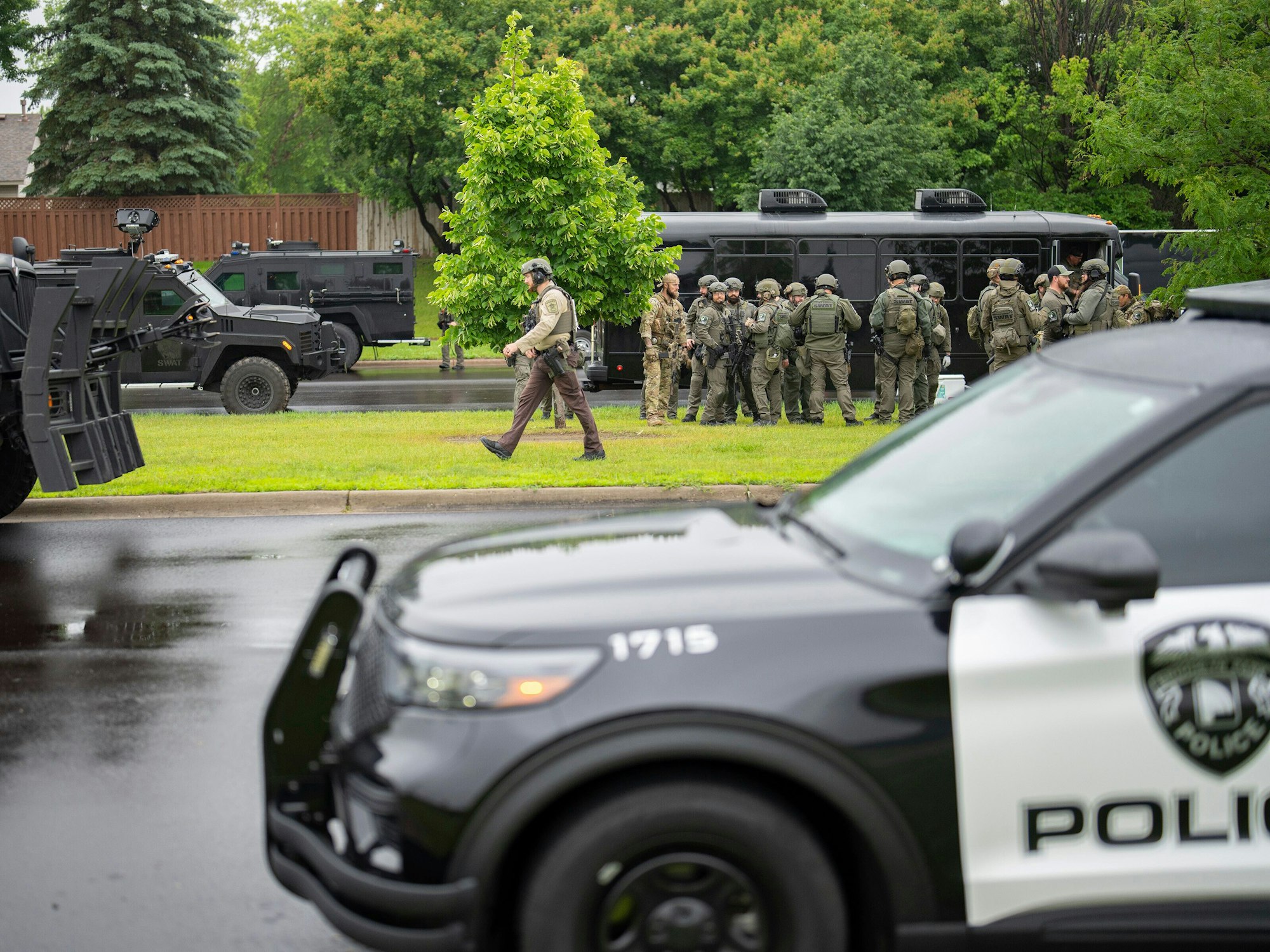 Beamte der Strafverfolgungsbehörden, darunter die örtliche Polizei, Sheriffs und das FBI, stehen nach dem tötlichen Angriff auf US-Politikerin Melissa Hortman weniger als eine Meile vom Unglücksort in Brooklyn Park, Minnesota entfernt.