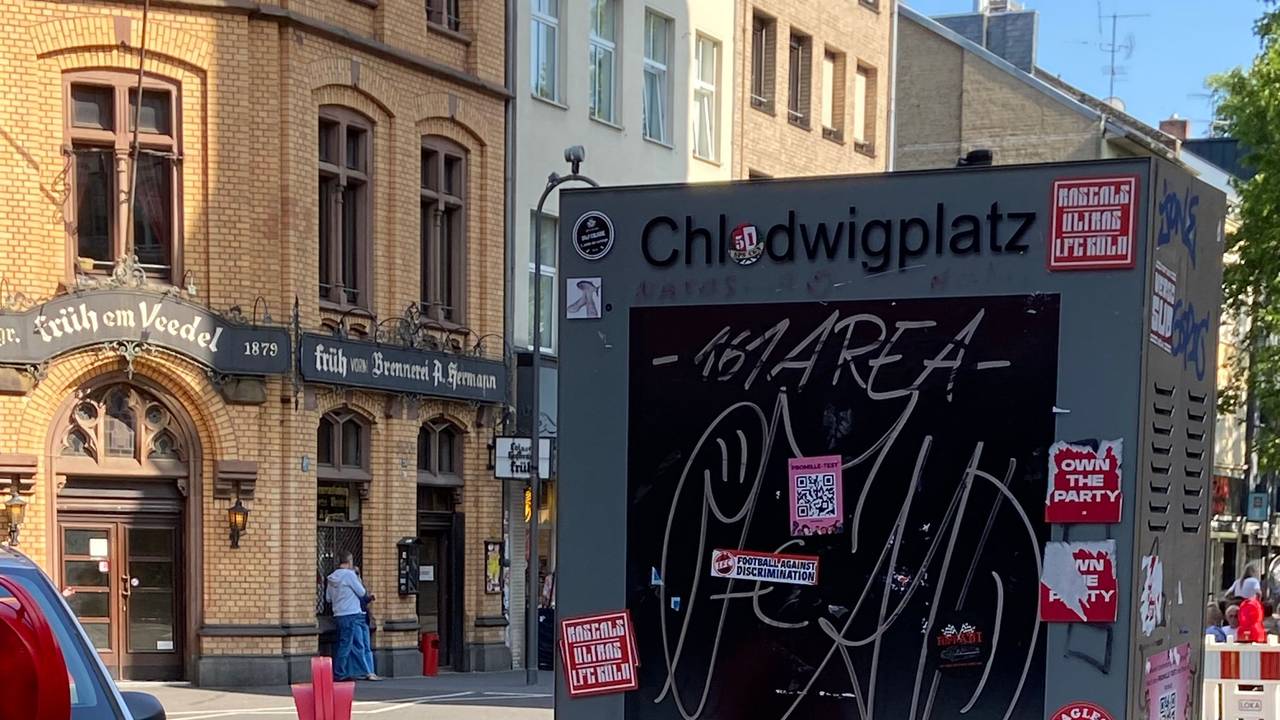 Eine Infosäule an einer Straße ist beschmiert und mit Aufklebern beklebt.
