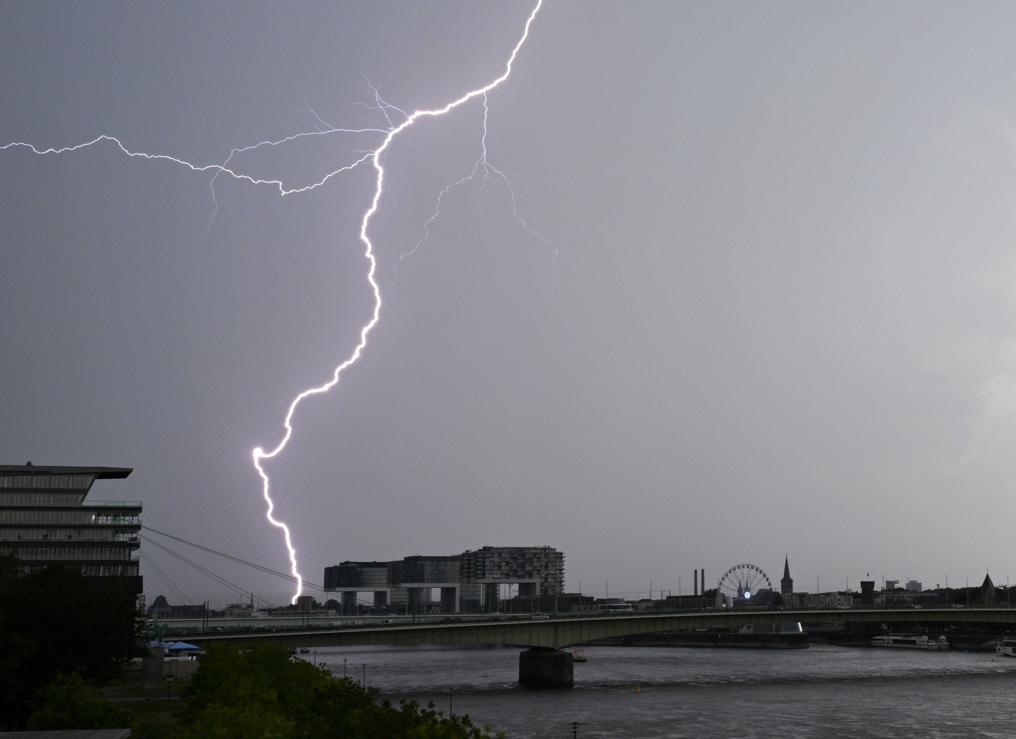 Ein Blitz zuckt bei einem Gewitter über dem Himmel über dem Kölner Süden.