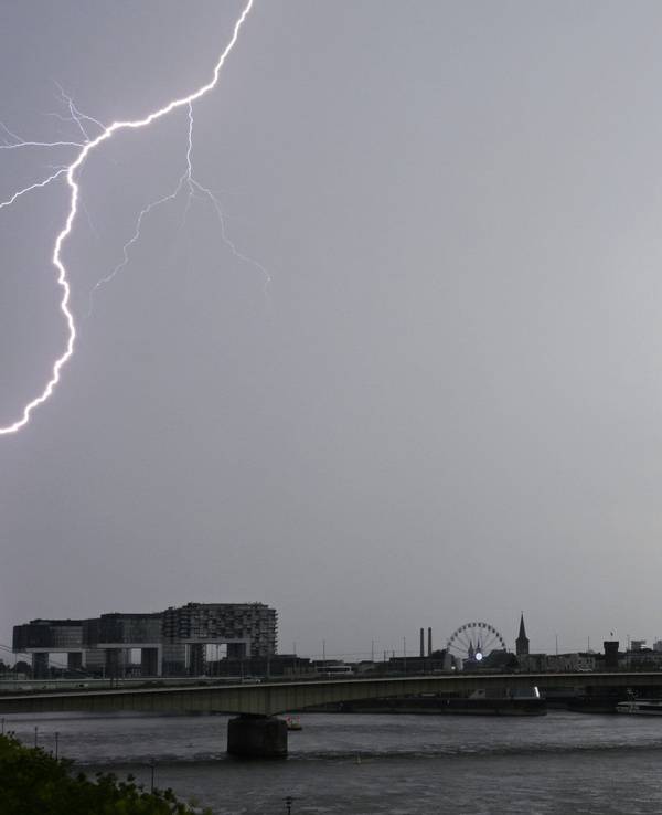 Ein Blitz zuckt bei einem Gewitter über dem Himmel über dem Kölner Süden.