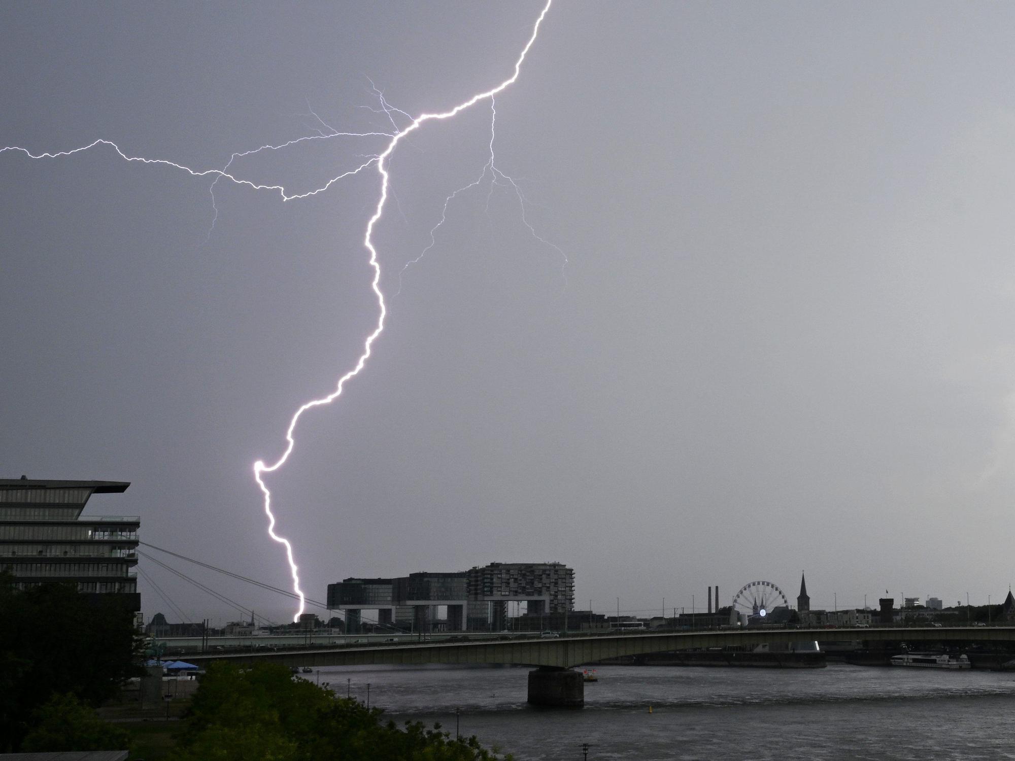 Ein Blitz zuckt bei einem Gewitter über dem Himmel über dem Kölner Süden.