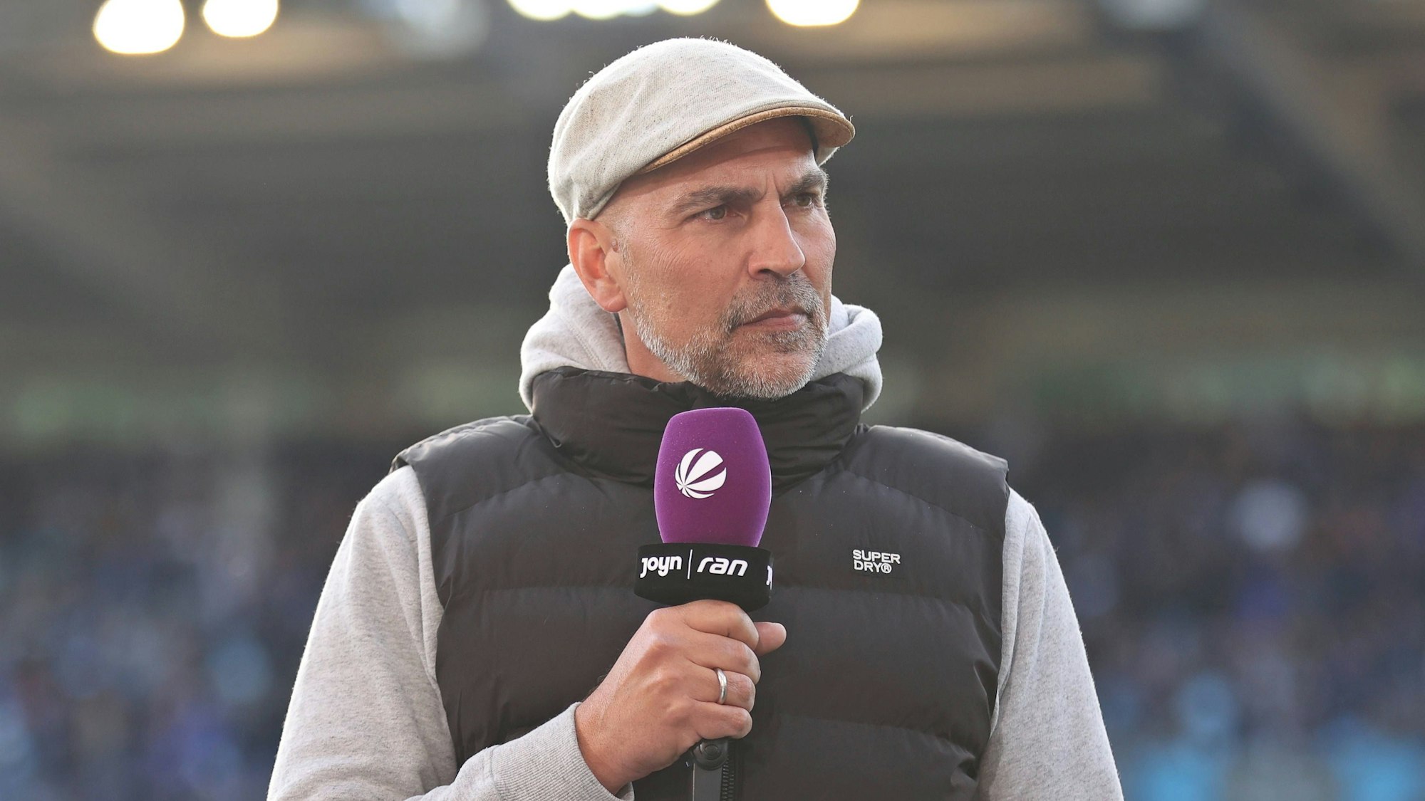 Markus Babbel hält ein Mikrofon mit dem Sat.1-Logo in der Hand.