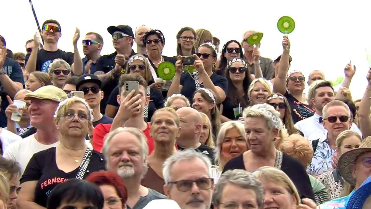 Die Fans vermissen Andrea Kiewel und halten Papp-Früchten hoch.